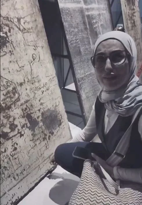 بالفيديو| شابة تتفاجأ باسم شقيقها على باب زنزانة سجن في معرض دمشق
