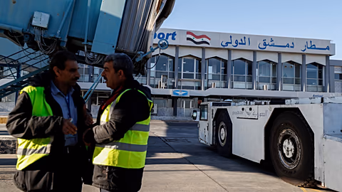 عاملون على مدرج مطار دمشق خلال استئناف الرحلات الداخلية، في 18 كانون الأول 2024.